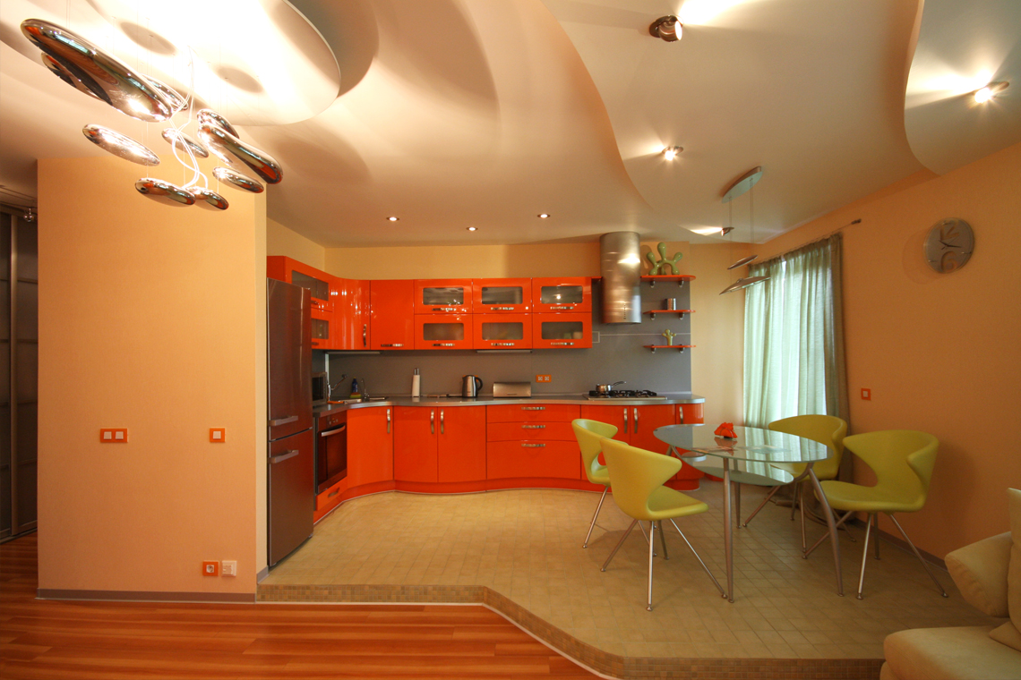Волнообразные фасады кухни подчеркнуты формами сложного потолка.